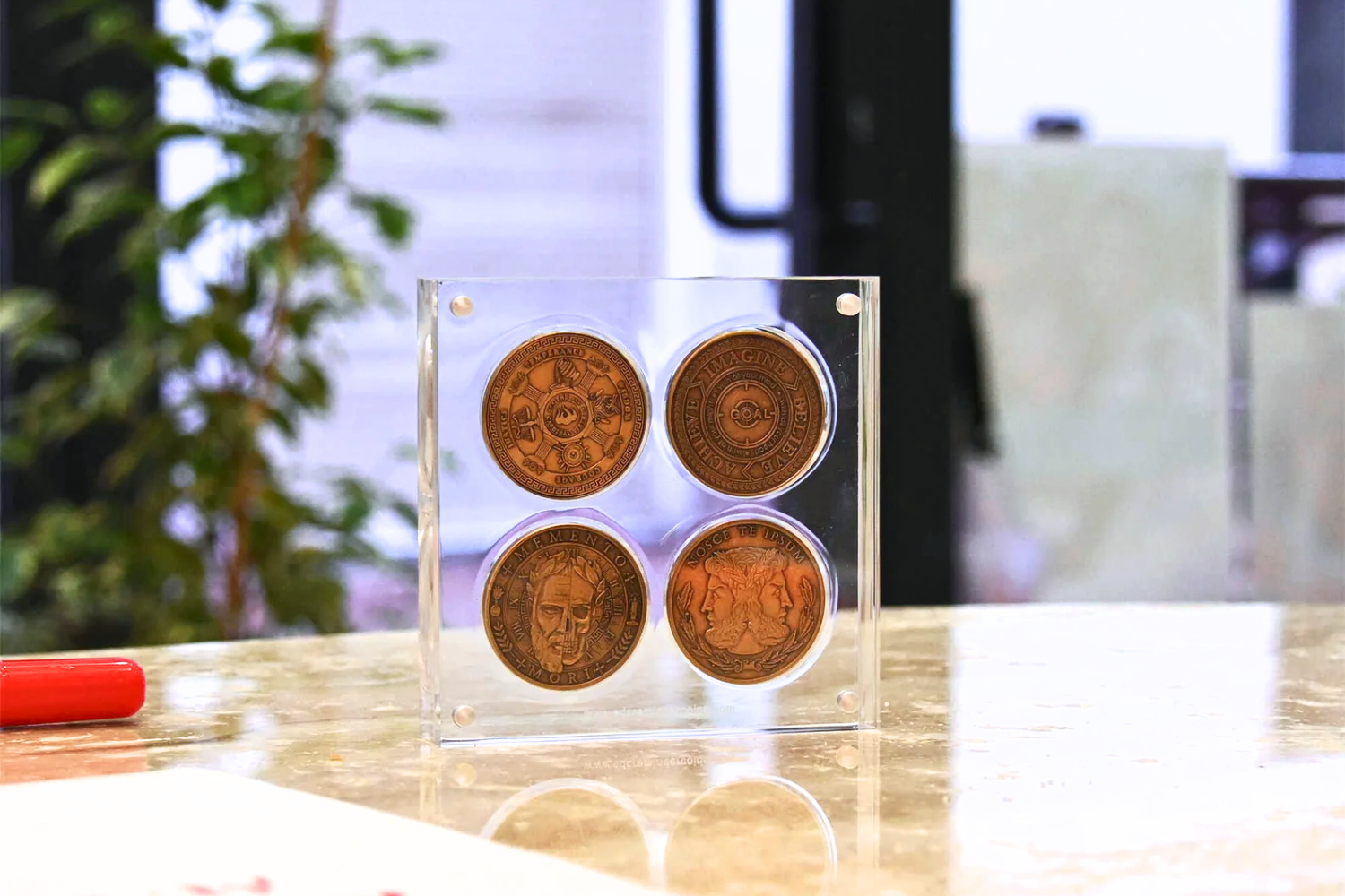 A picture of a floating challenge coin display, holding four challenge coins.