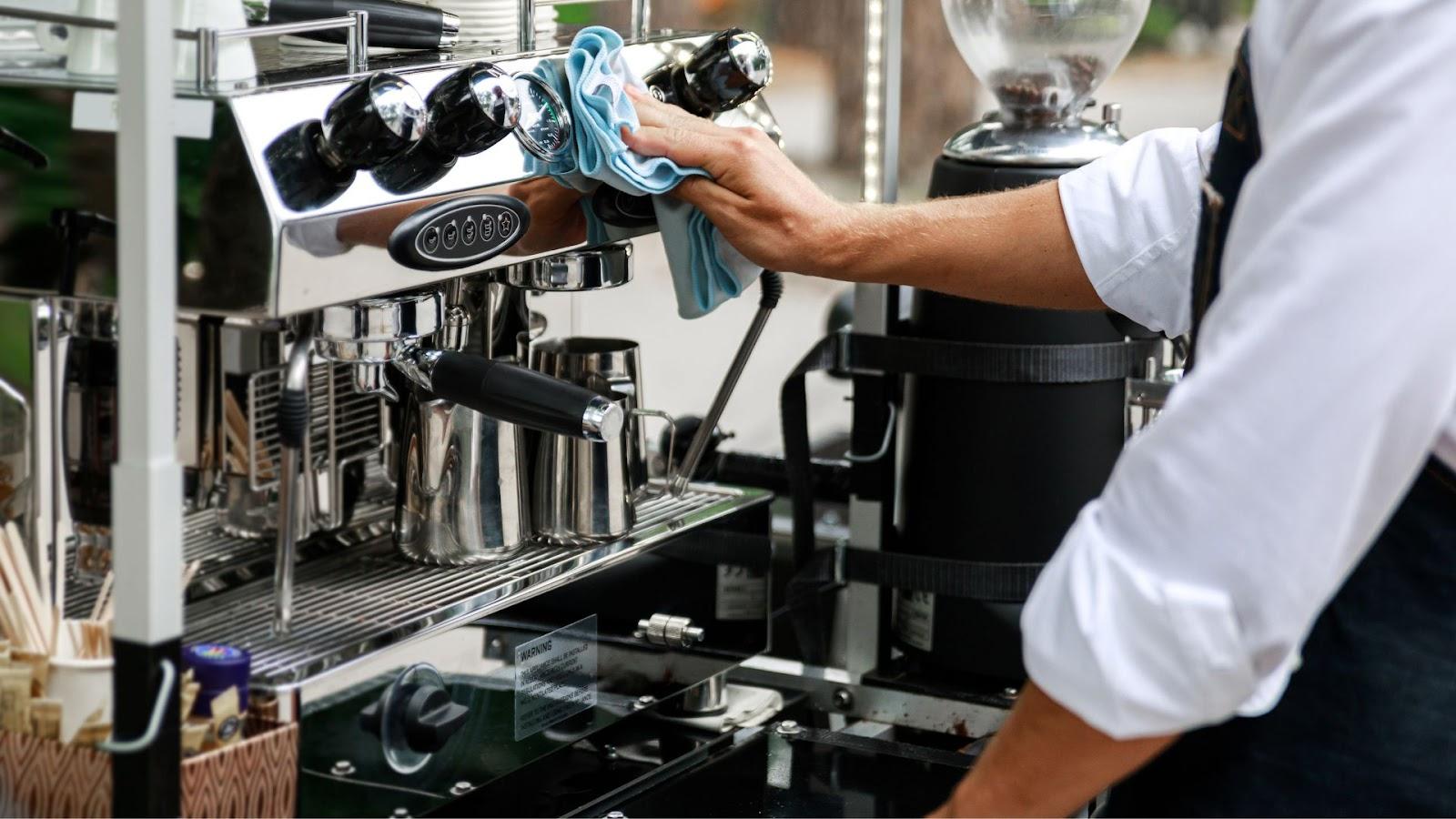 a barista cleaning espresso machine with a towel