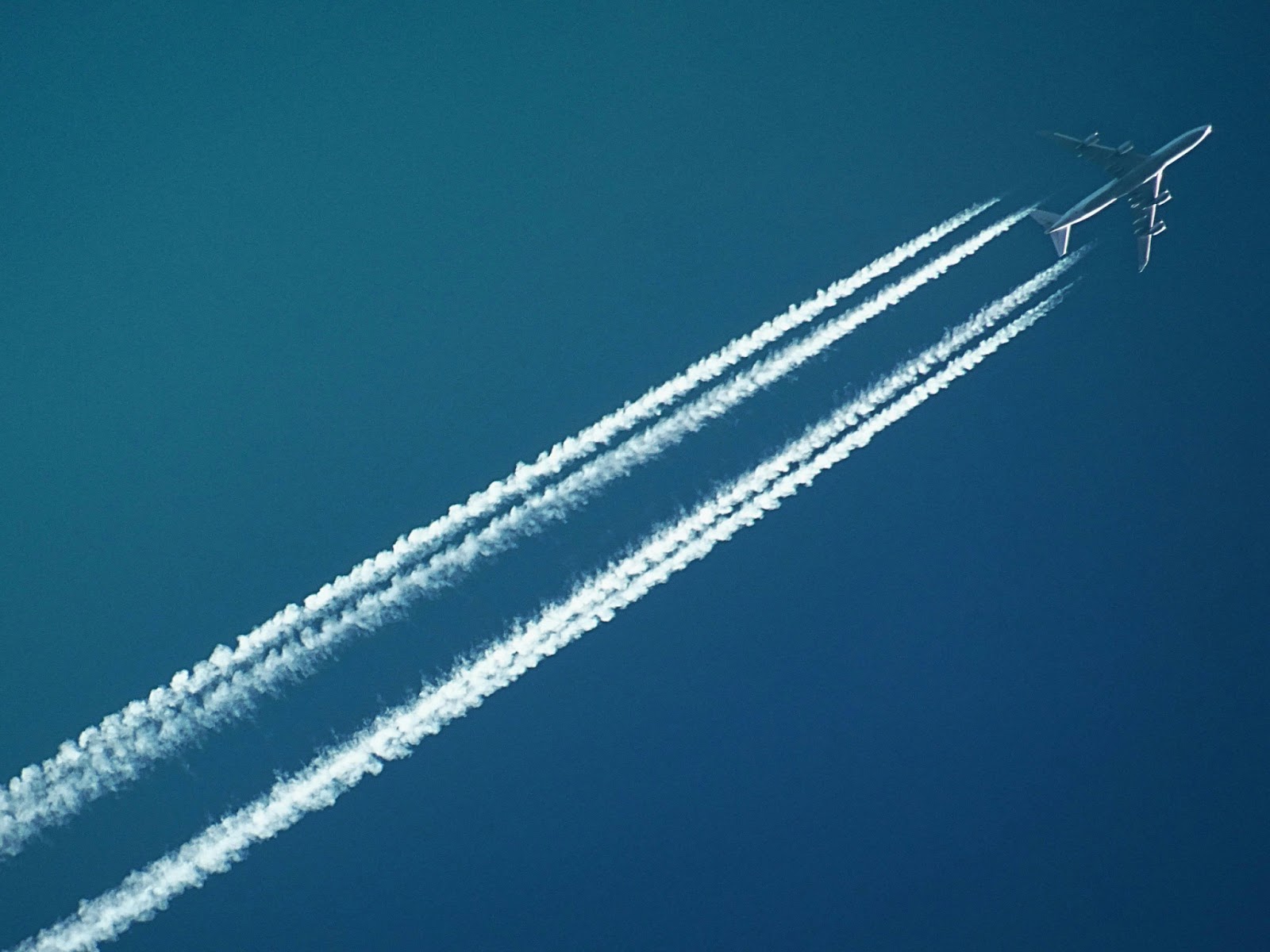 A plane in the sky, depicted with chem trails, flying to the next sunny destinations for a nice October escape. 