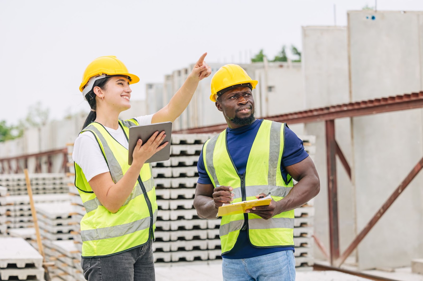 Masonry contractor collaborating with an African Black worker during precast concrete casting.