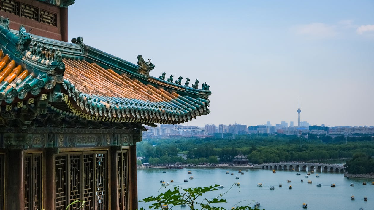 Chinese temple in the foreground with the skyline of Beijing in the background, representing cultural heritage and urban development