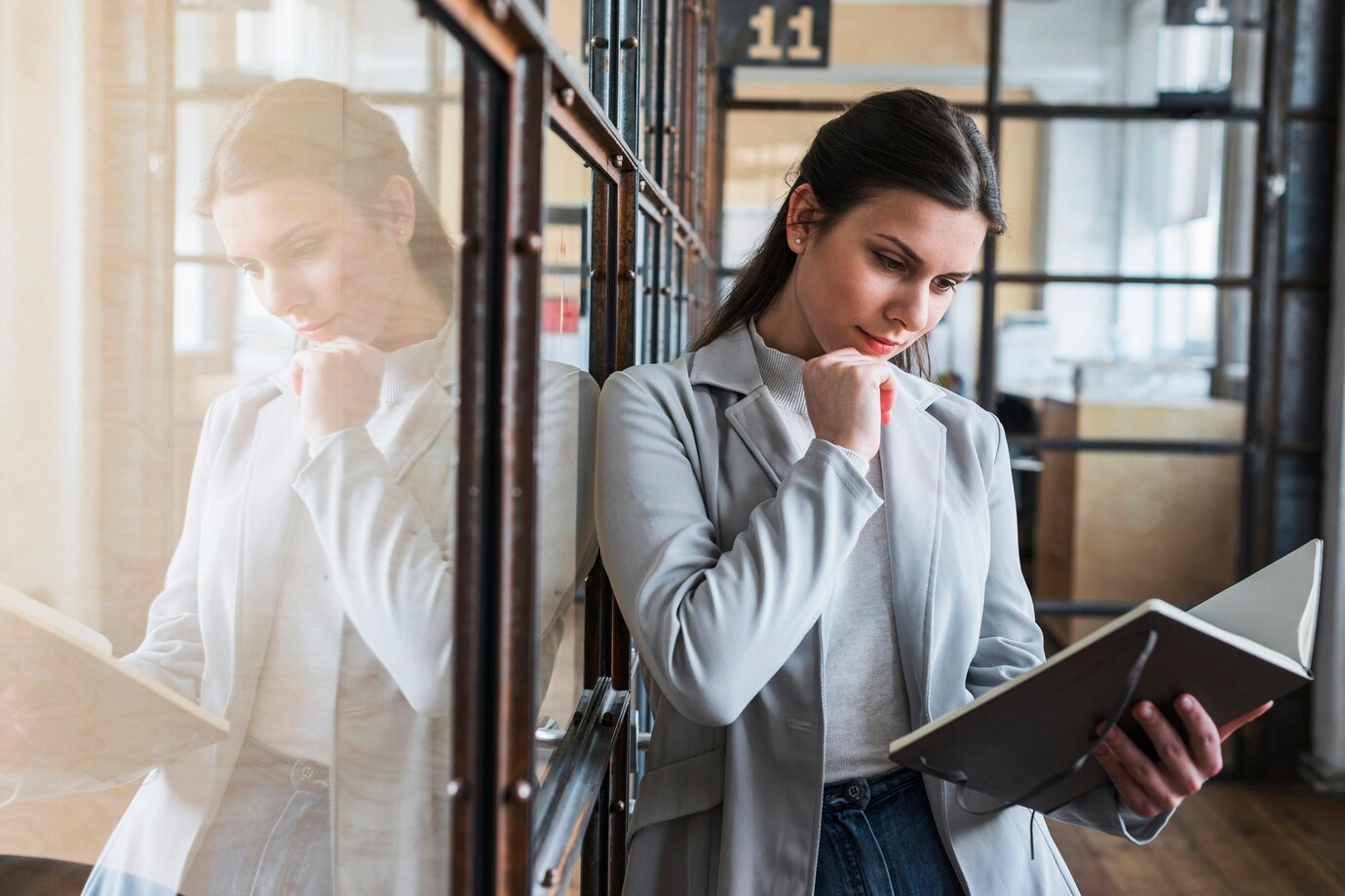 Alt text: Focused young woman reviewing her diary at her office desk.