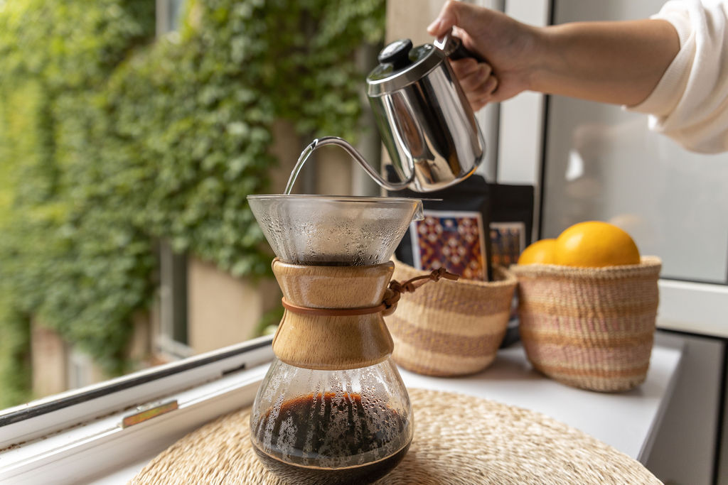 Individual pouring arabica coffee grounds into a coffee maker, ready to brew a rich and aromatic cup of coffee.