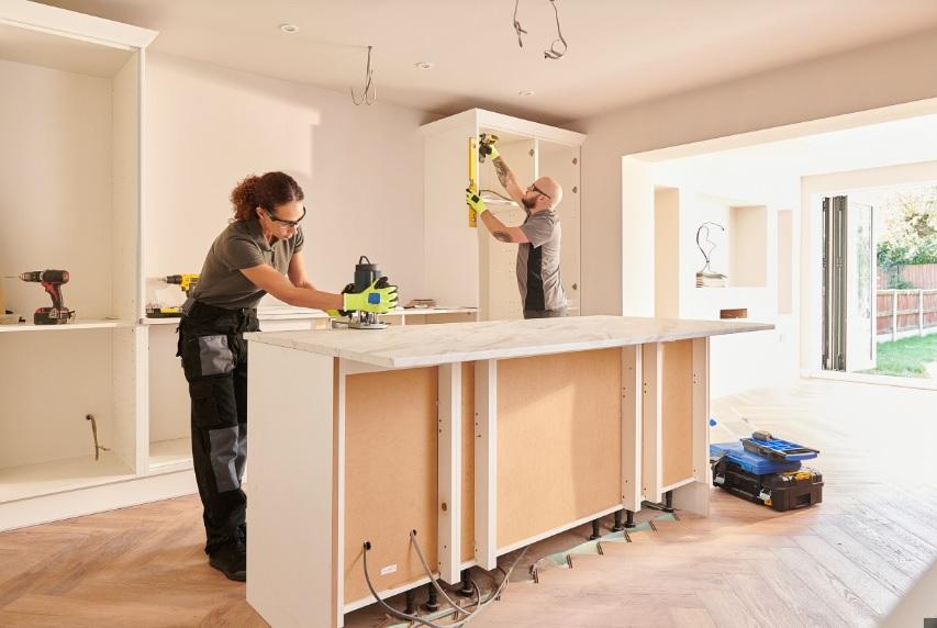 A couple of people working in a kitchen

Description automatically generated