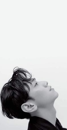 This contain an image of Nam Yoon Su with his head tilted to the side looking up putting on a black cloth