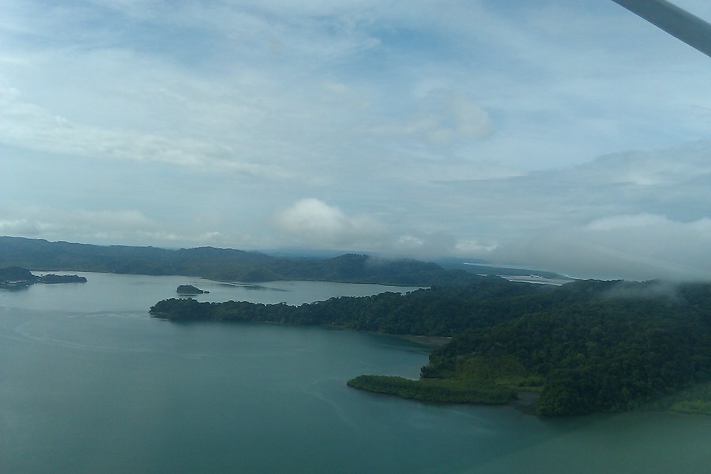 A misty view of the Osa Peninsula featuring dense forest and a serene water body.