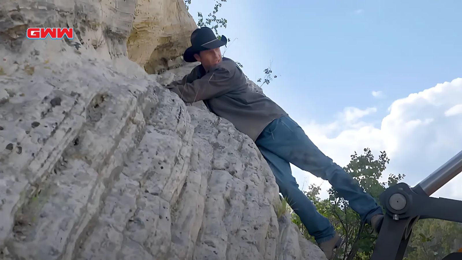 Chad Ollinger scaling cliff face while searching for hidden treasures