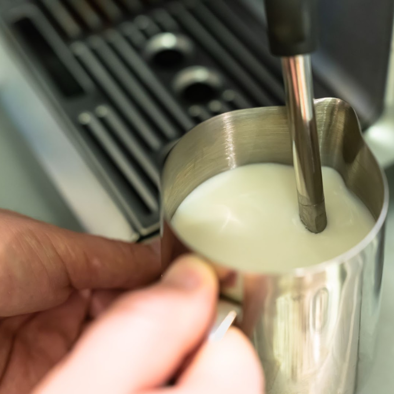 steaming milk in a pitcher