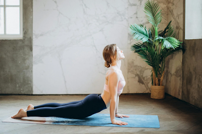 A woman practicing yoga in a serene environment, showcasing strength and flexibility, an essential approach to improving recovery and overall well-being