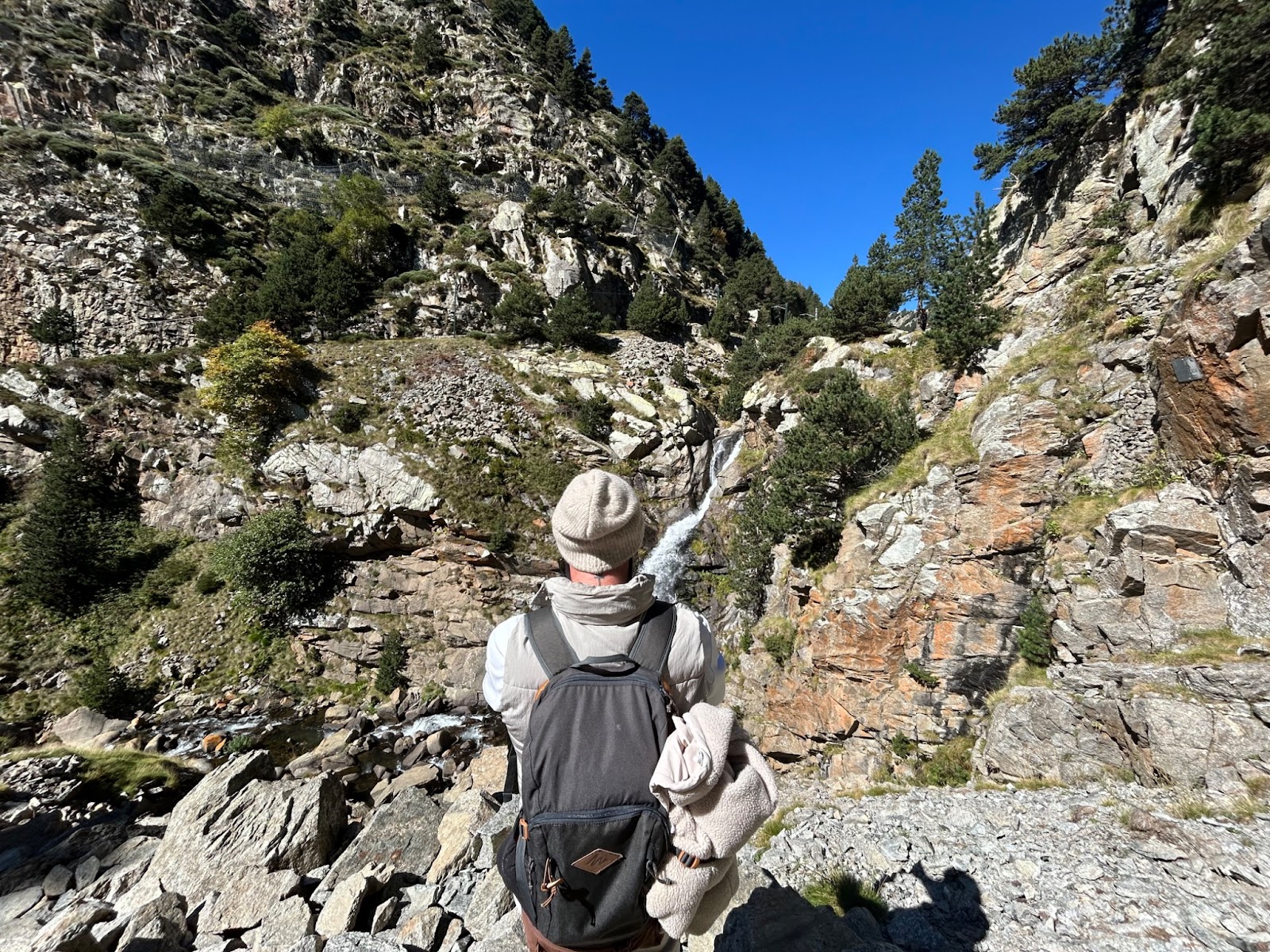 A photo of the different stones and a waterfall in Vall de Núria with Diego camouflaged.