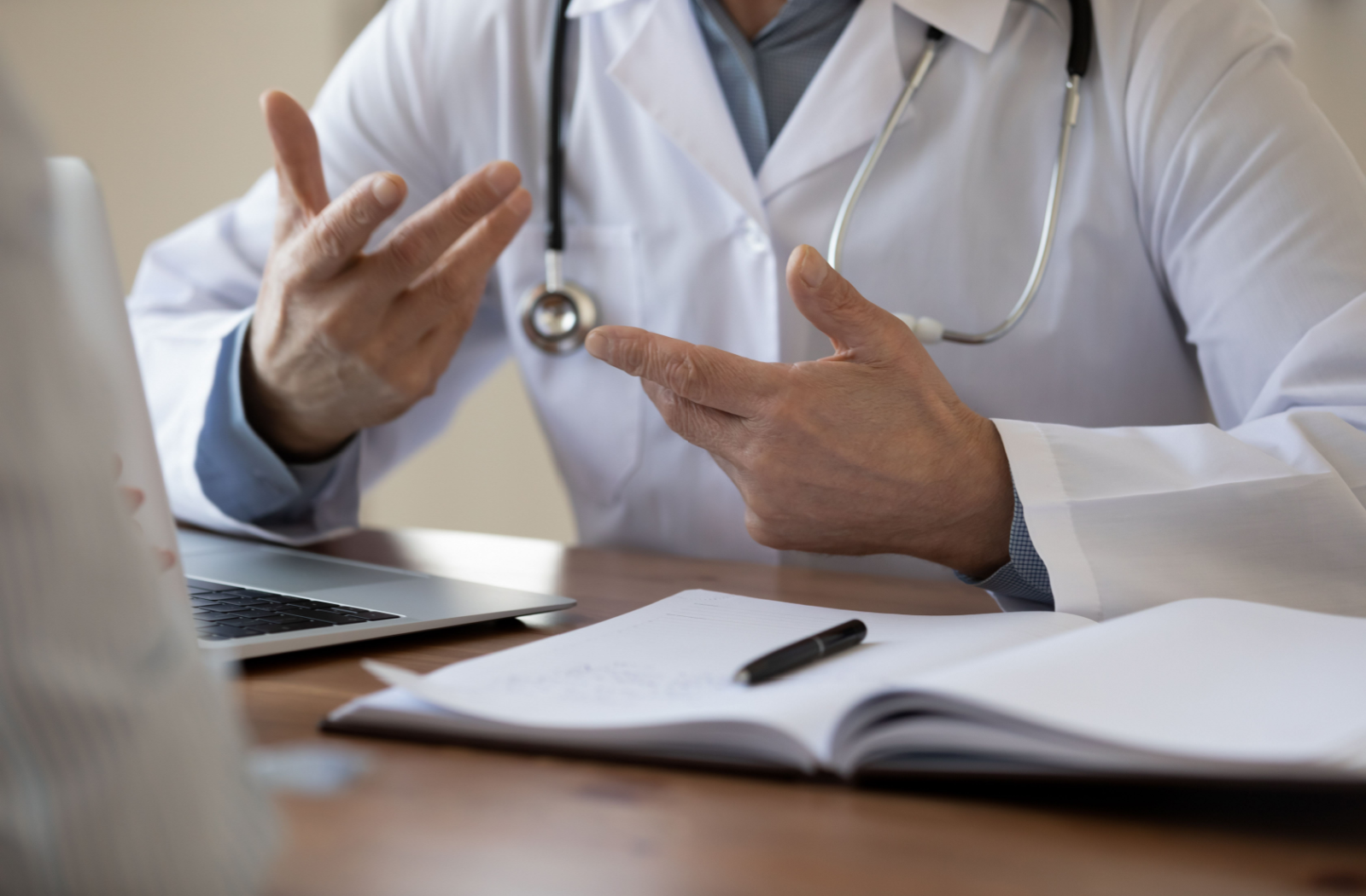 Close-up of a senior doctor's hands moving as they speak.