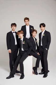 This may contain an image of  FTISLAND's members in suits are posing for a photo