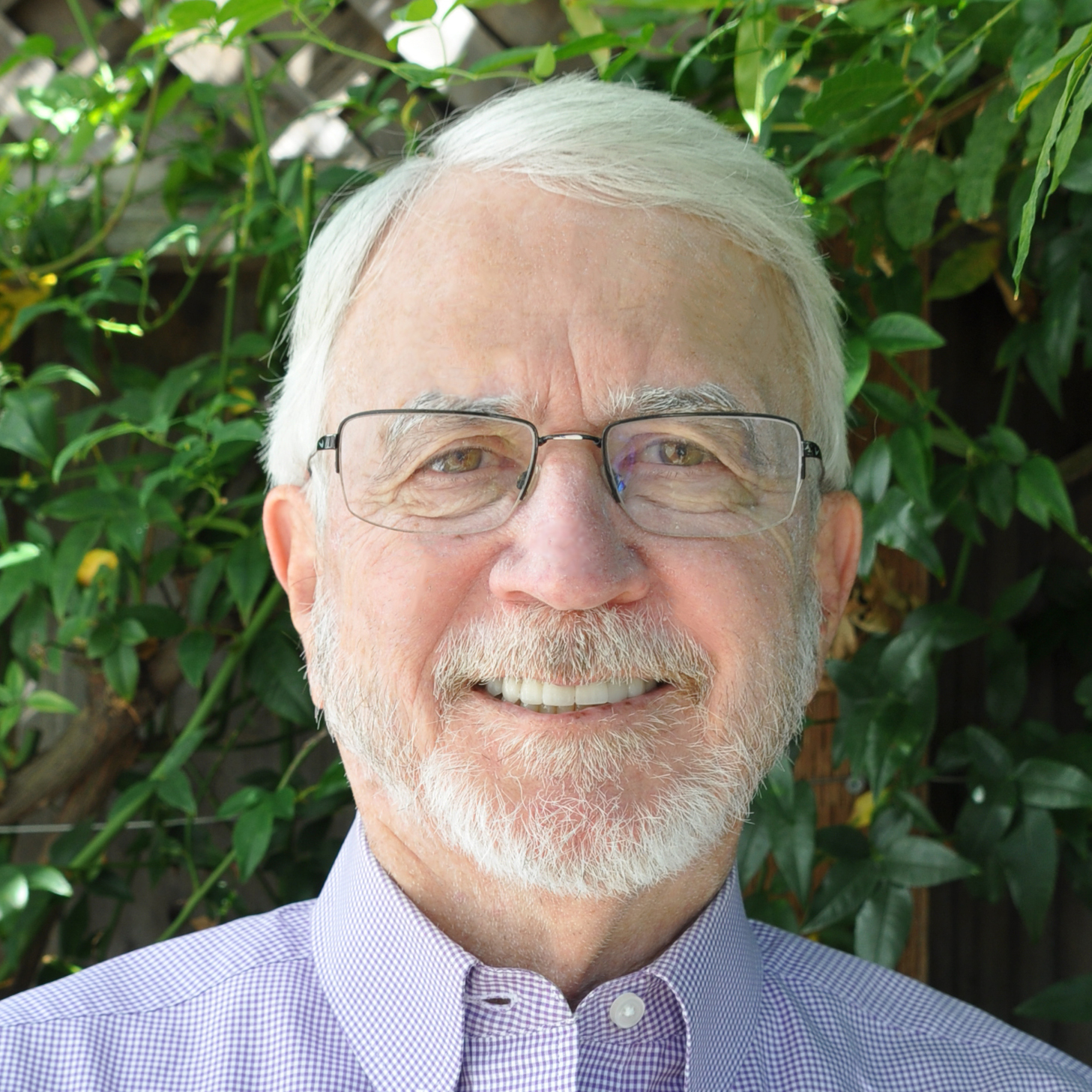 A person with white hair and beard wearing glasses Description automatically generated