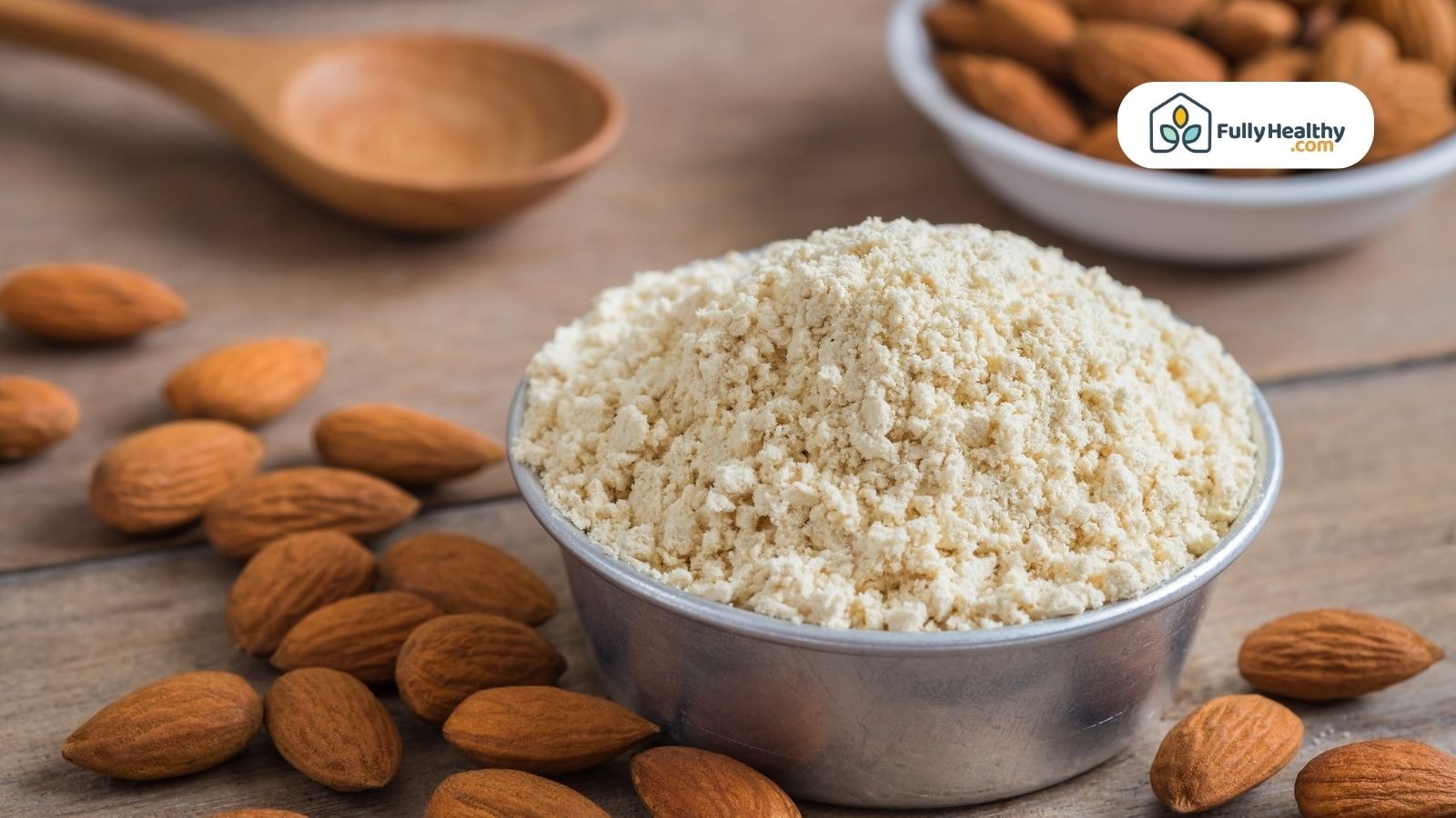 Bowl of almond flour surrounded by whole almonds on wooden table