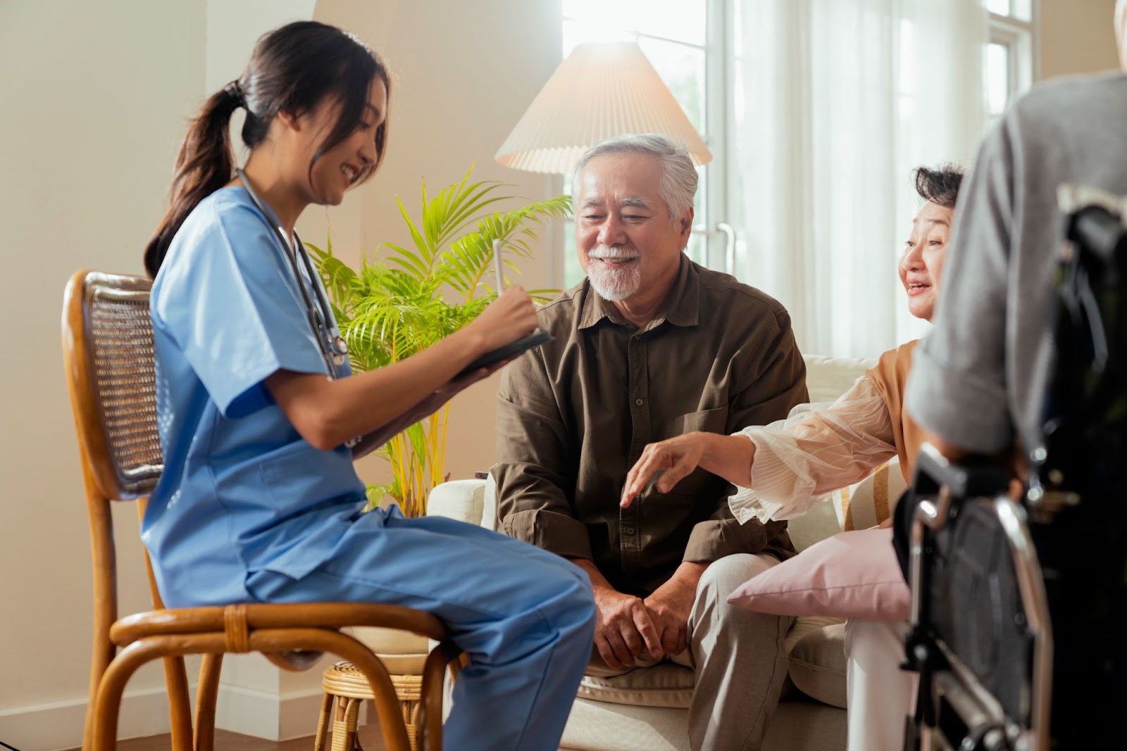 A carer speaking with an elderly couple in their home.
