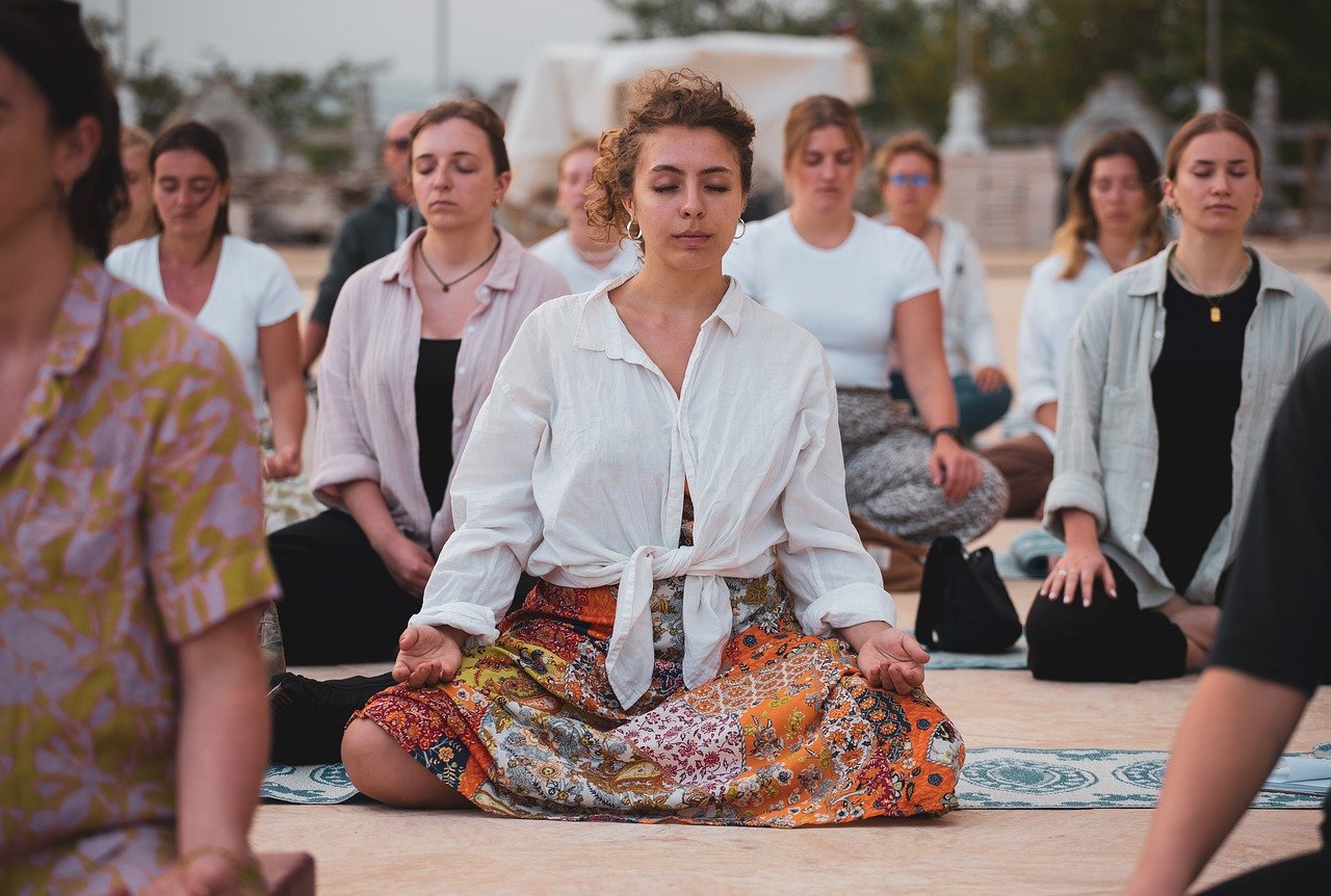 Várias mulheres meditando para aliviar sintomas físicos e emocionais