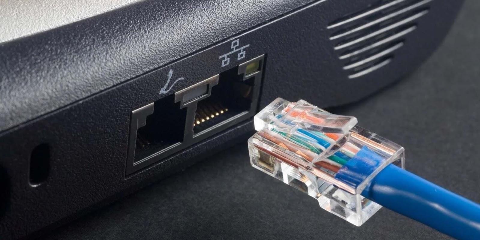 A blue Cat6 cable routed to a gaming laptop