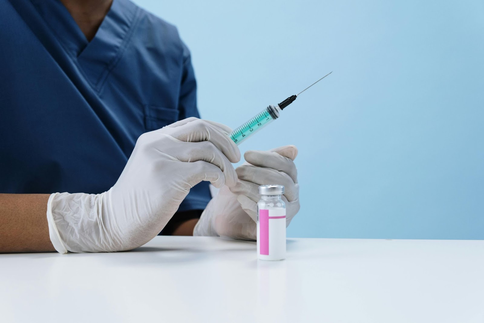 A medical staff member holding a syringe in their hand, ready for use