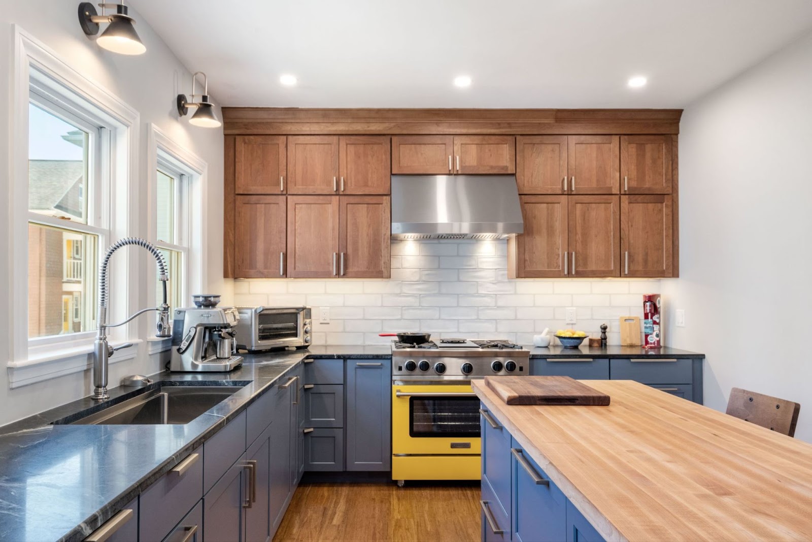 This image depicts a kitchen showcasing wooden and blue full overlay cabinets for a sleek look. 