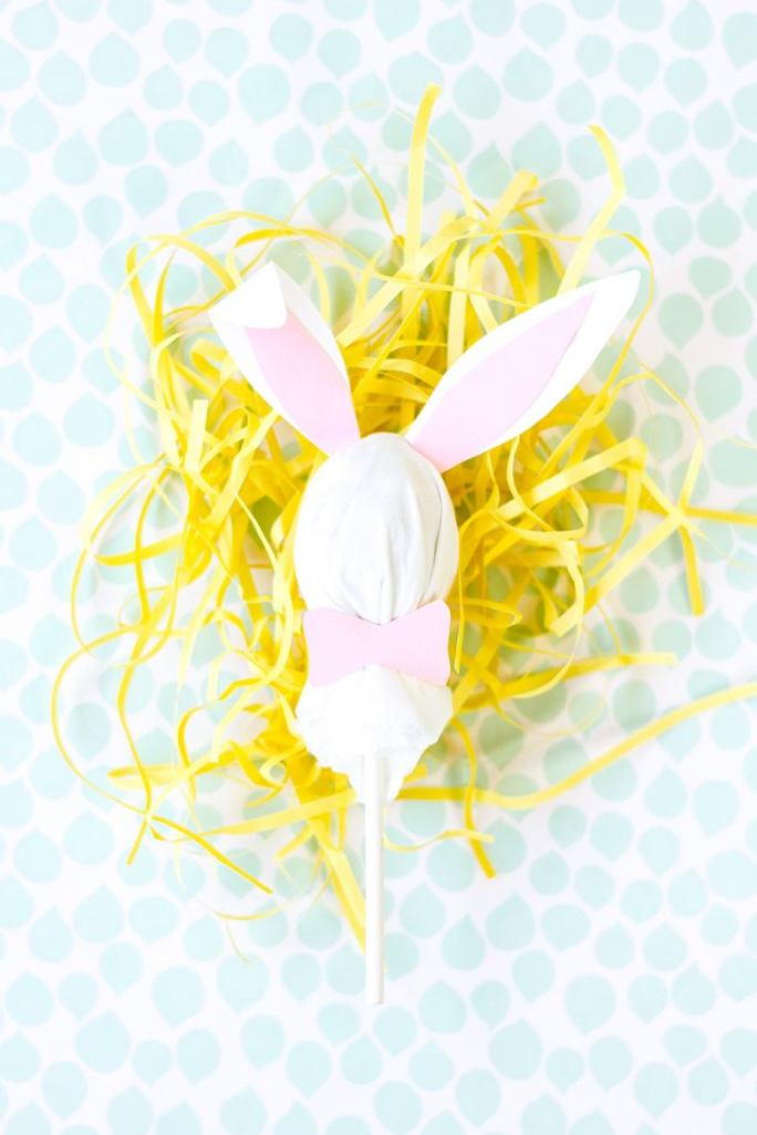 easter egg hunt ideas white diy lollipop with bunny ears on top of yellow tissue paper