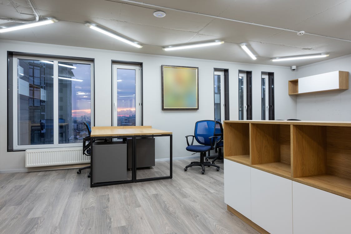 Free Spacious and contemporary office space with large windows and minimalist furniture. Stock Photo