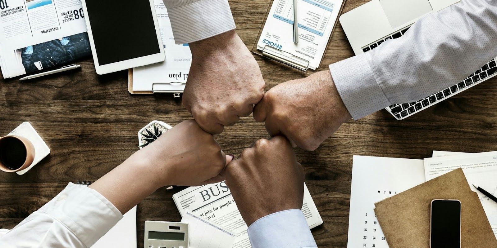  Colleagues fist-bumping at a table