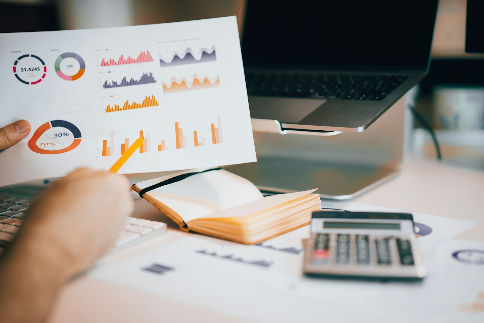 A paper displaying charts and graphs with a laptop on a background