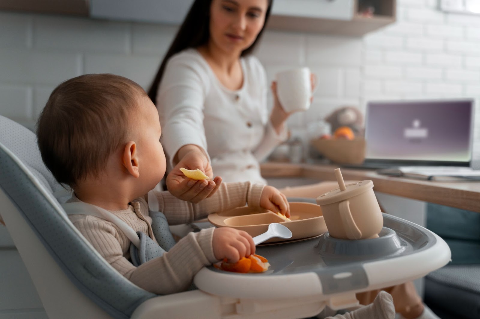 Mother feeding her baby in a high chair