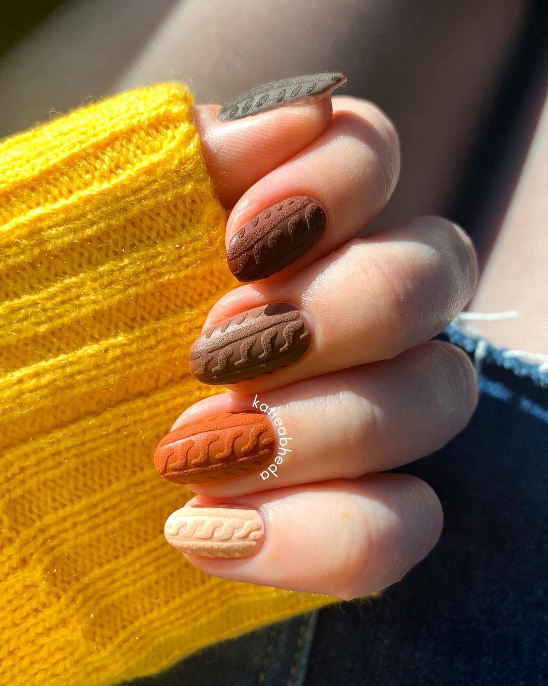 Close-up of hands with fall nail design having Embossed Patterns