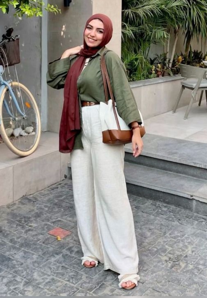 Wanita dengan kulot cream dan blouse olive.