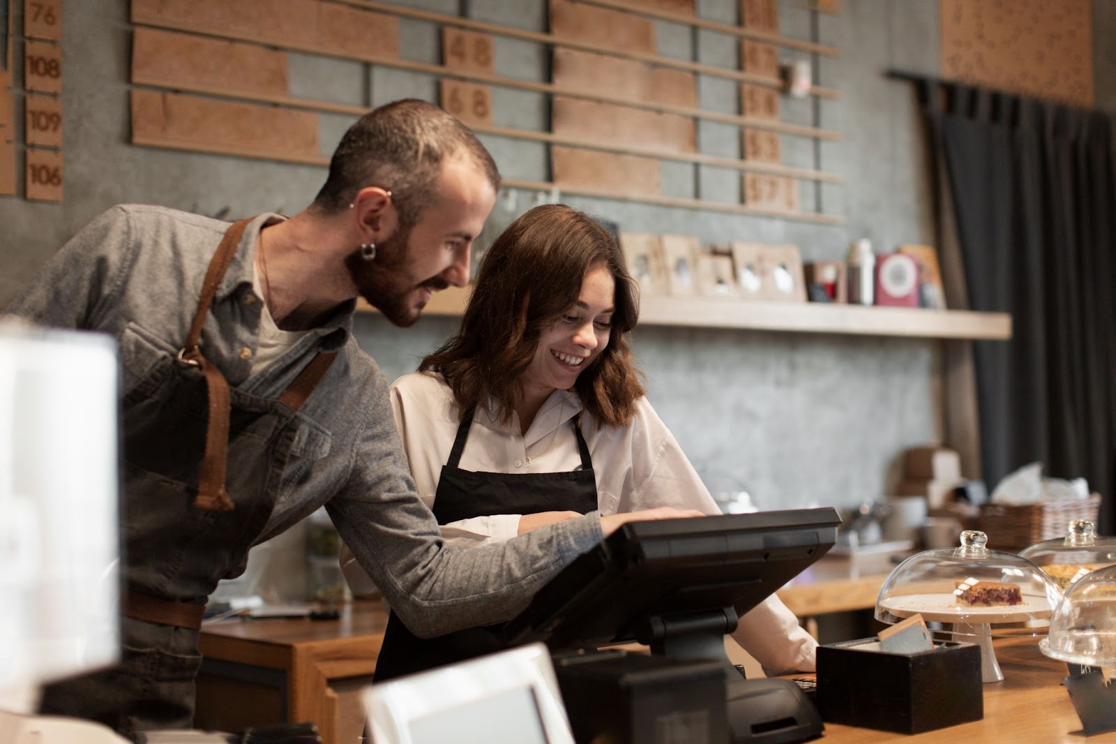 Dos empleados revisan la caja registradora de un café moderno