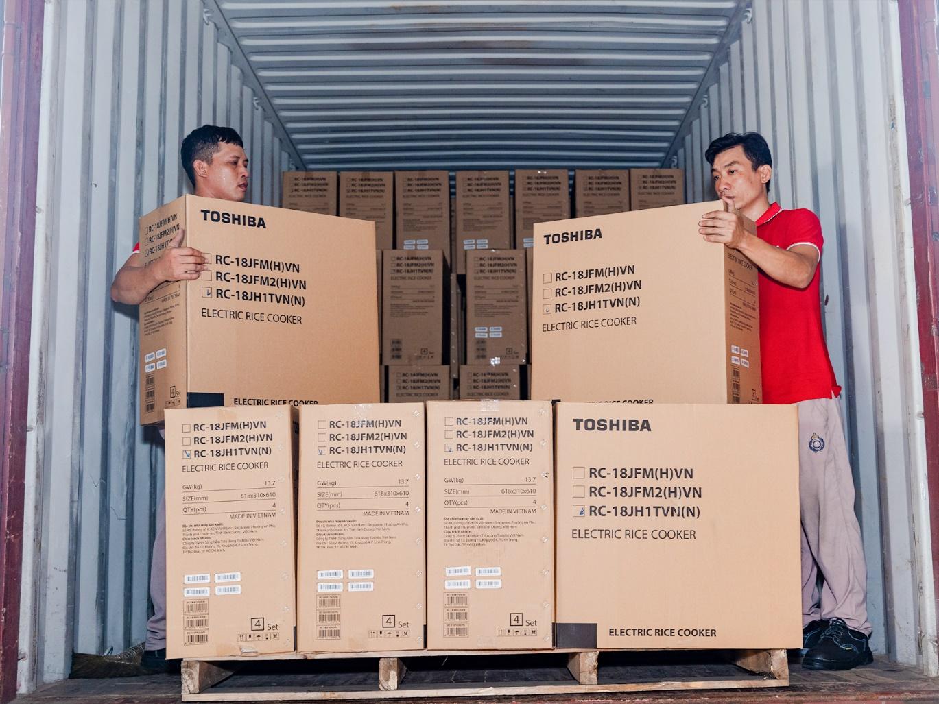 Men carrying boxes in a shipping containerDescription automatically generated