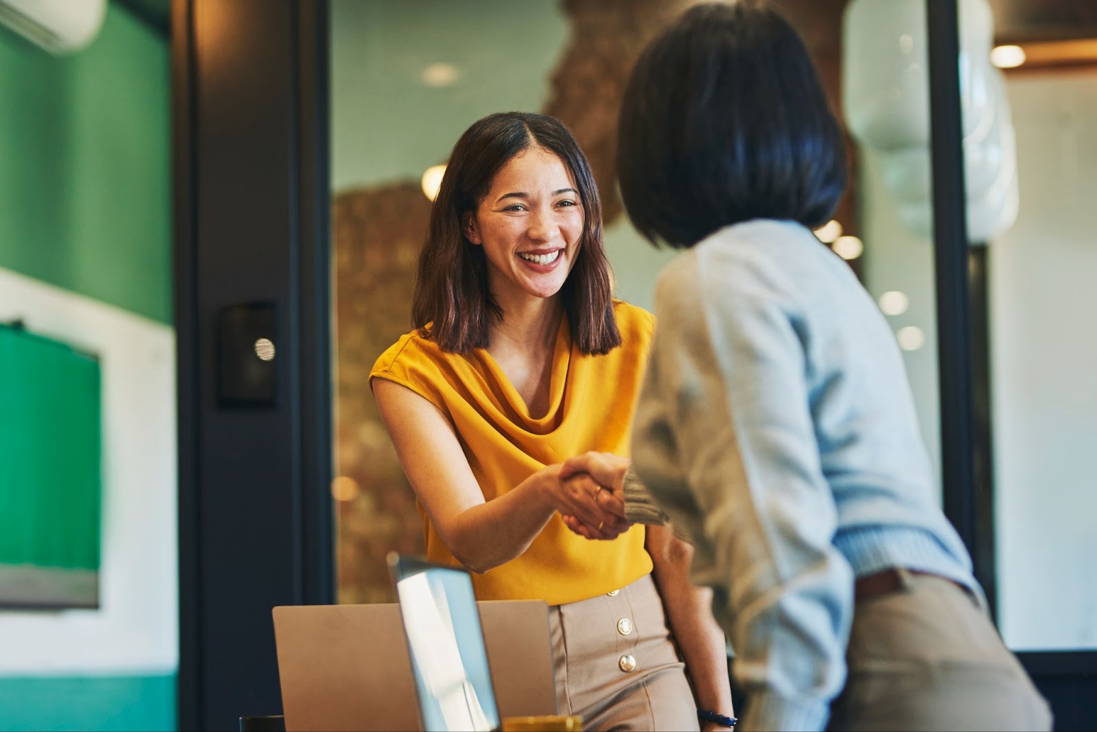 Two business women shaking hands in collaboration