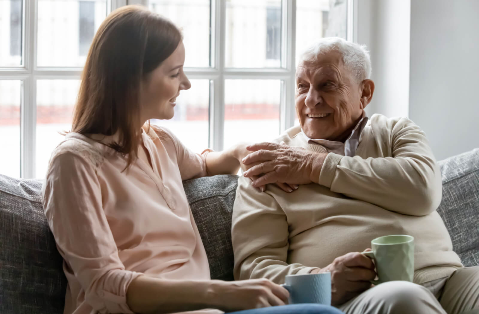 A woman attentively listening to her senior father.