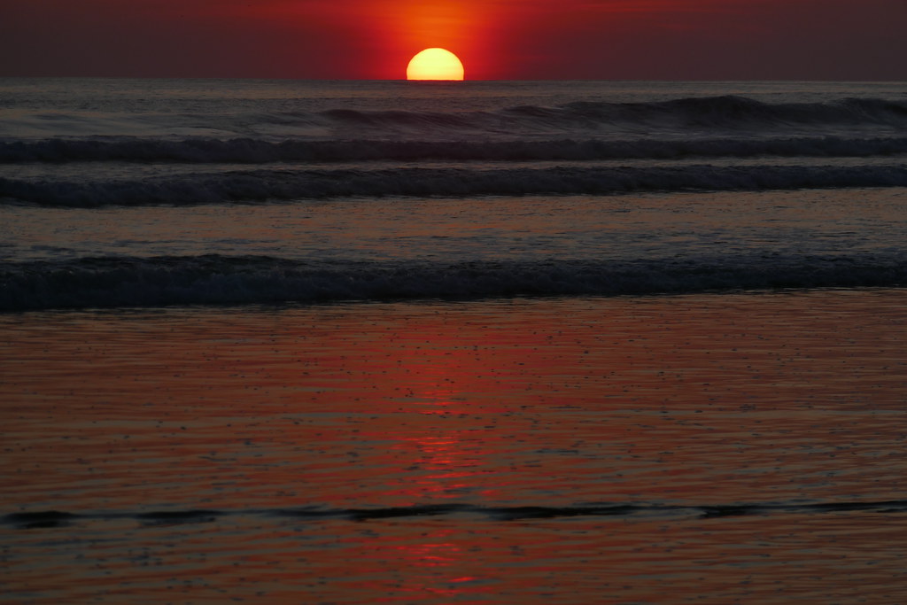 It's sunset time and sun turns into yellow color and sky turns into orange color and waves on the beach