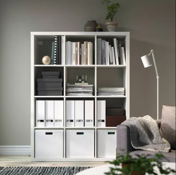 A white shelving unit with books and a lamp

Description automatically generated