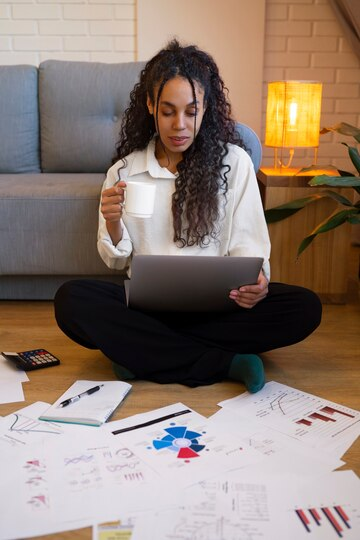 Full shot of a woman working with data on a computer thinking about topics about business