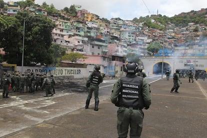 Integrantes de la Guardia Nacional Bolivariana despejan una calle bloqueada en el sector Primero de Mayo en Caracas.