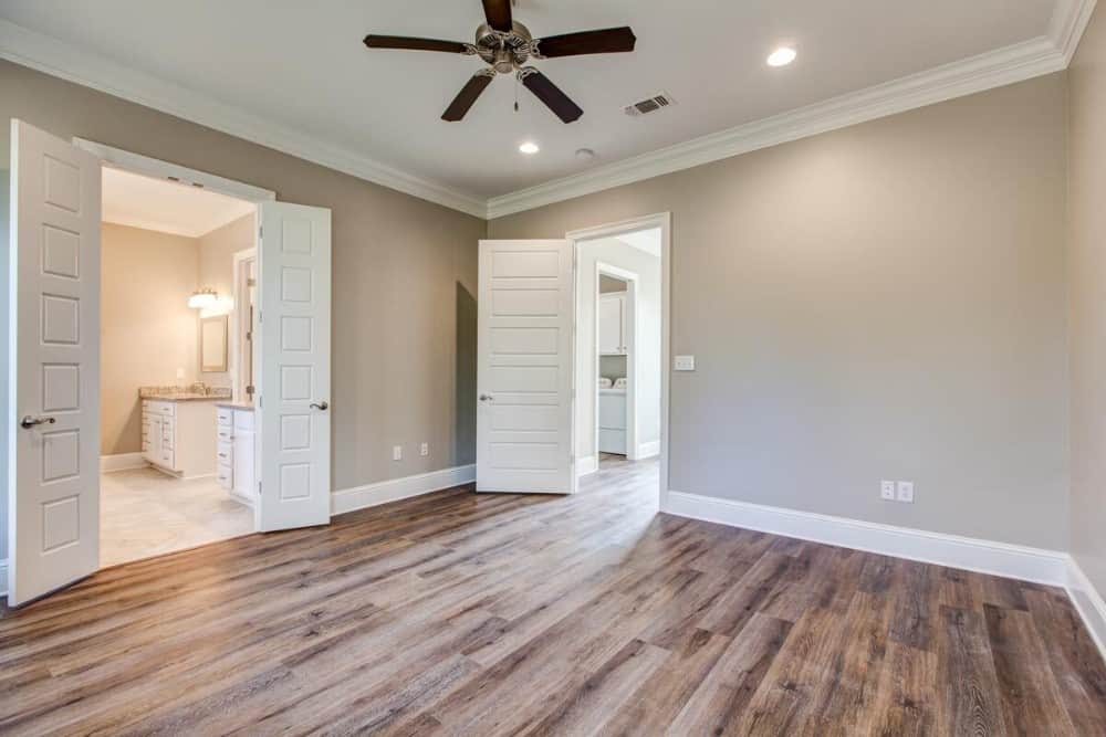 The primary bedroom includes a private bath enclosed in white double doors.