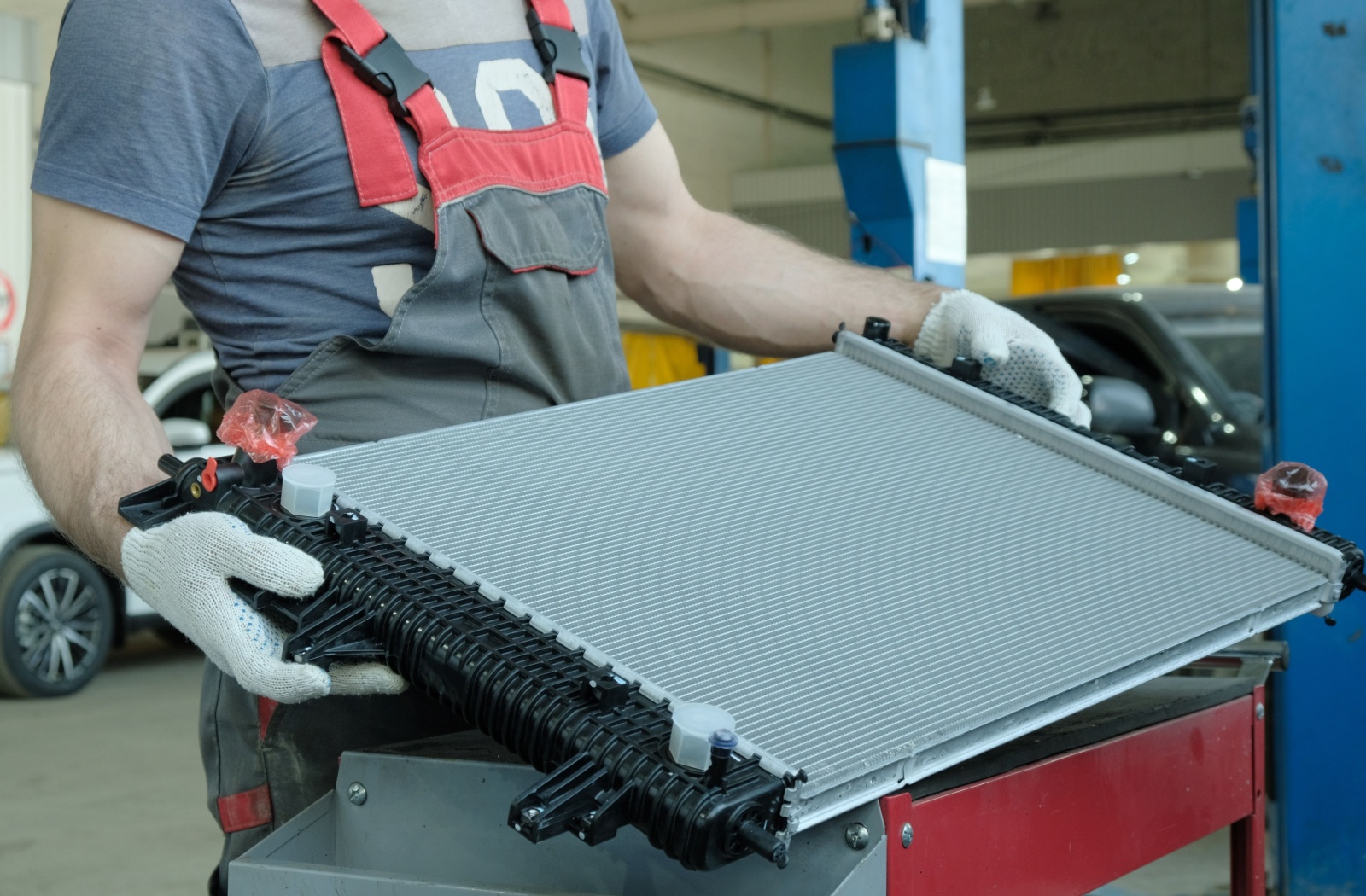 An auto mechanic inspects a new radiator before installing it