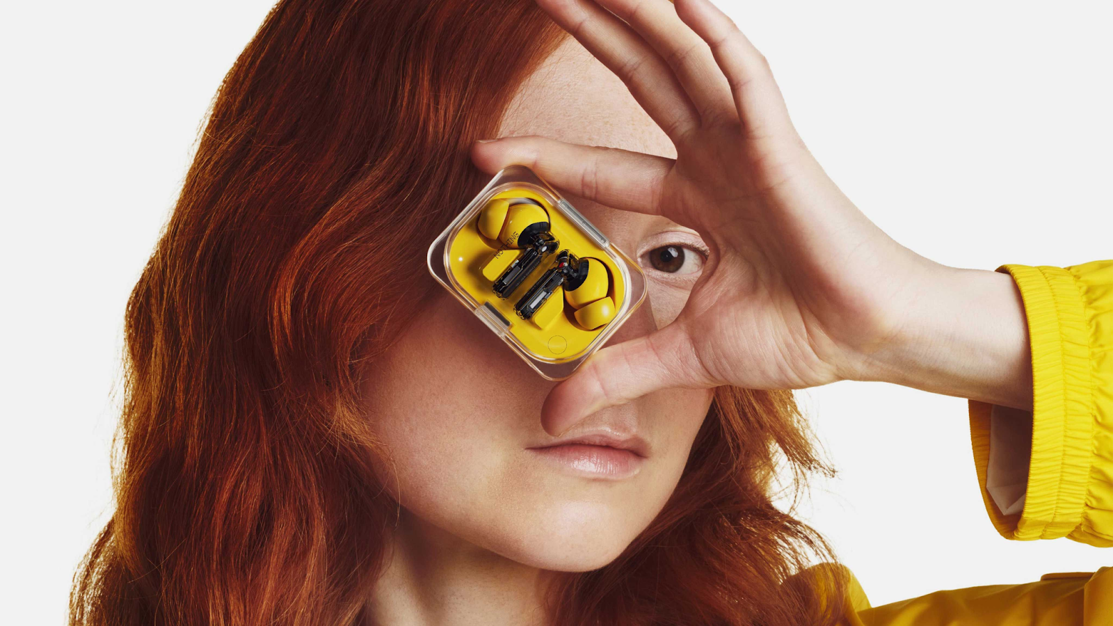a girl hold Nothing Earbuds ear (a) yellow