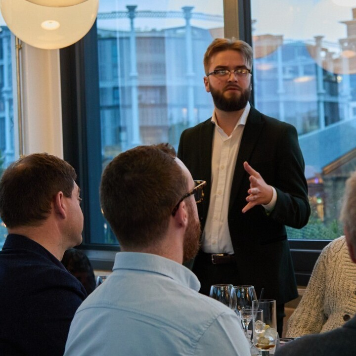 A photo of Rowan Payne talking to a bunch of retailers at a roundtable in London