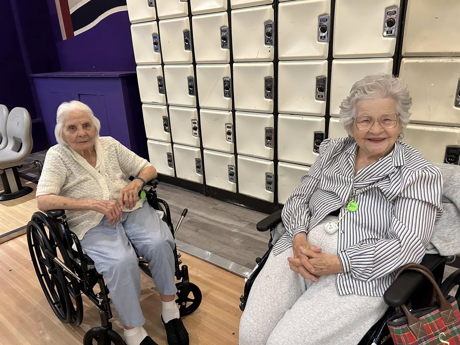 Two seniors in a wheelchair in front of lockers