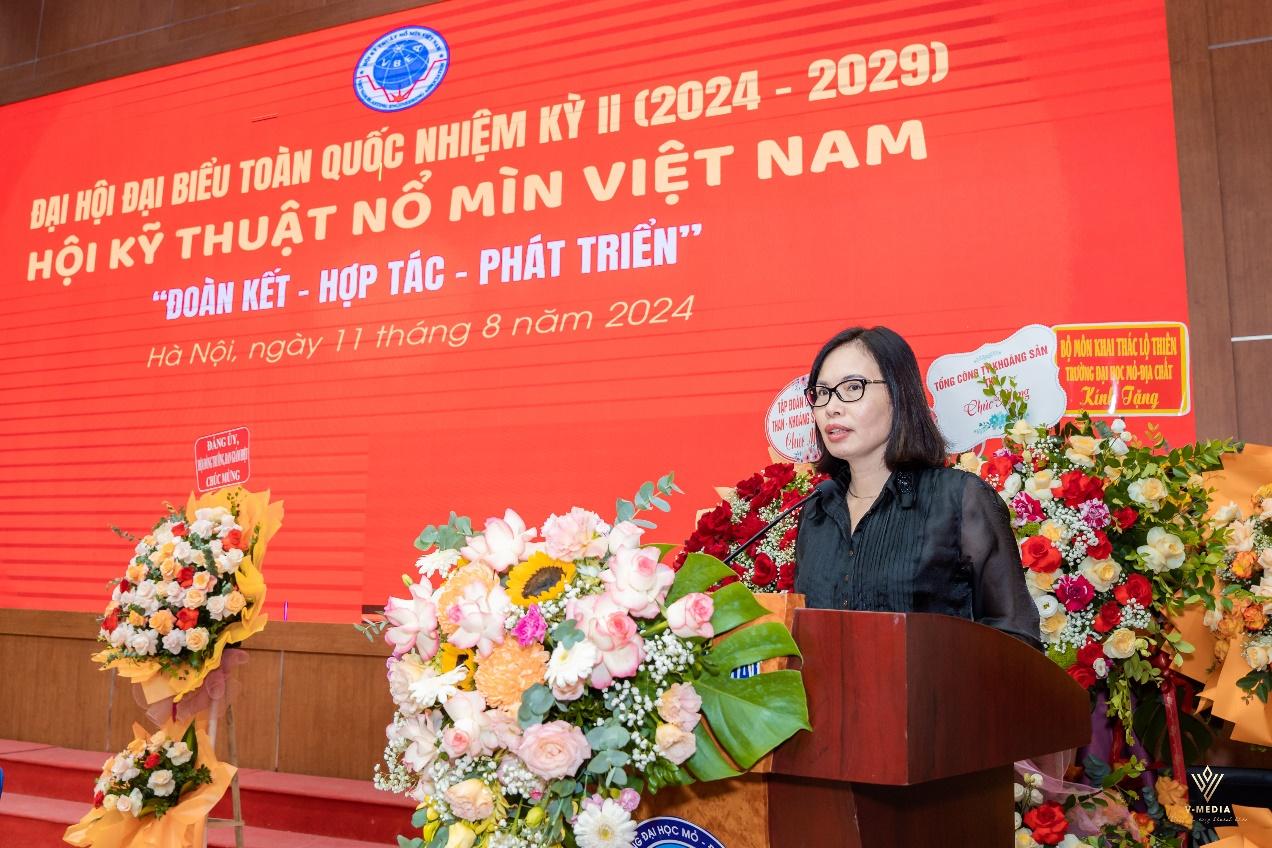 A person standing at a podium with flowers on it

Description automatically generated