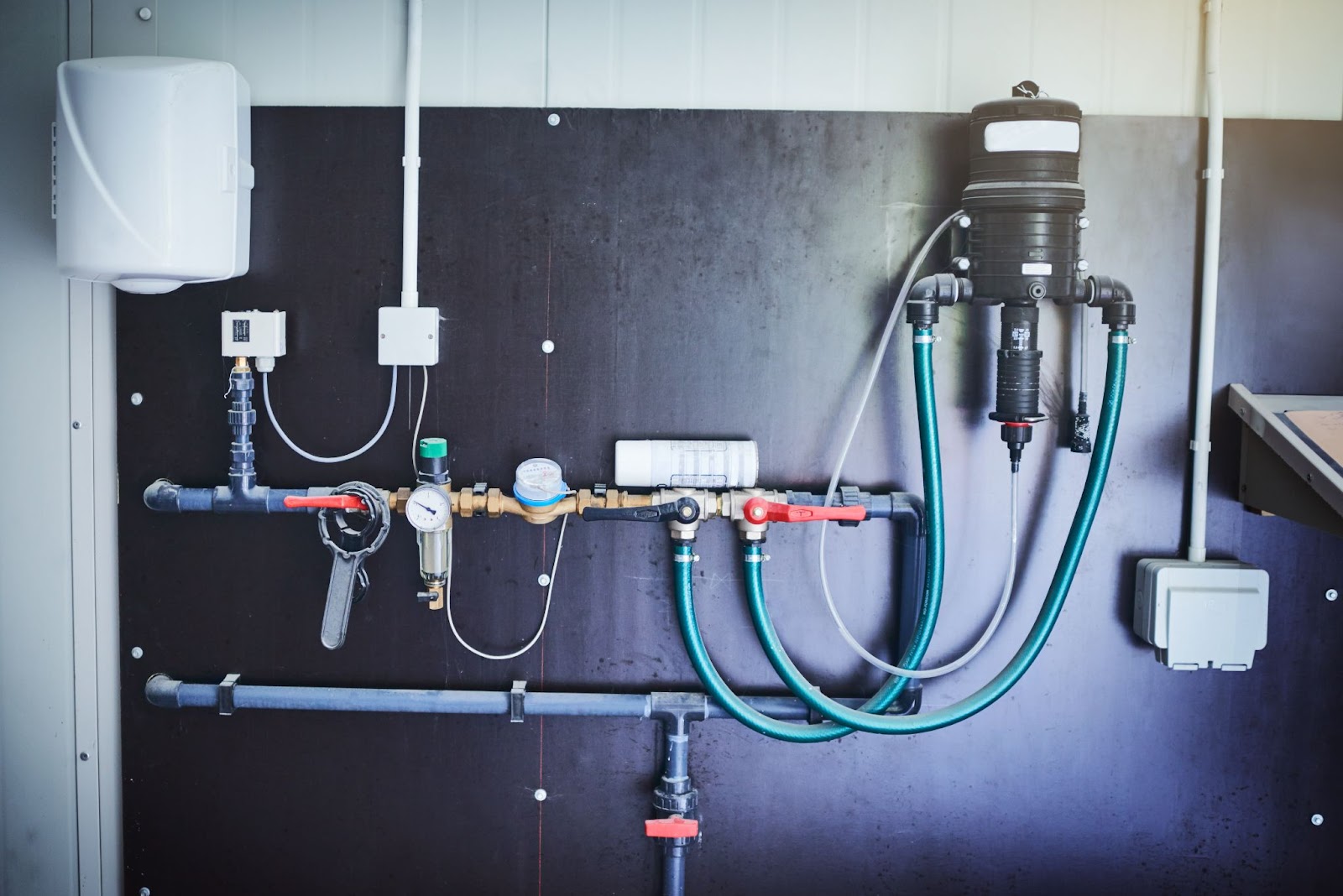 Industrial plumbing equipment mounted on a factory wall showcasing essential pipes, valves, and fittings that ensure efficient water flow and waste removal.