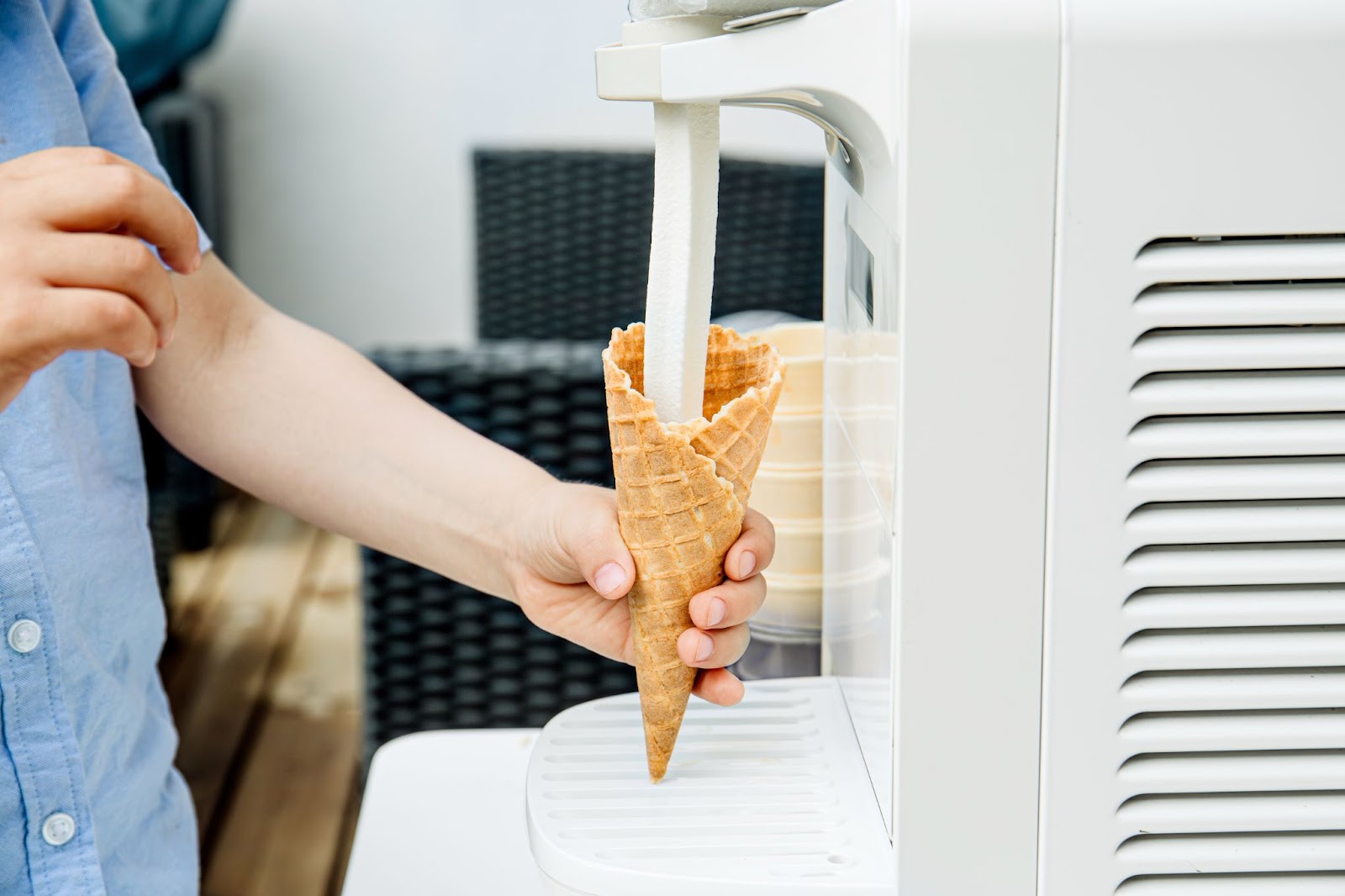 Ice cream cone being filled at soft service ice cream machine