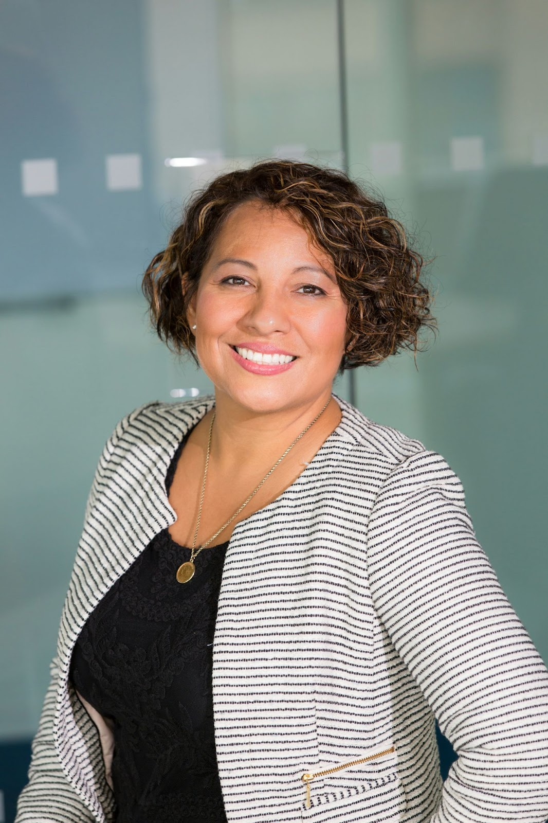 A woman posing for her headshot in an office environment