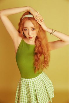 Yeonjung from WJSN wearing a lemon dress and a check shirt mixed with lemon and white with her hand on her head