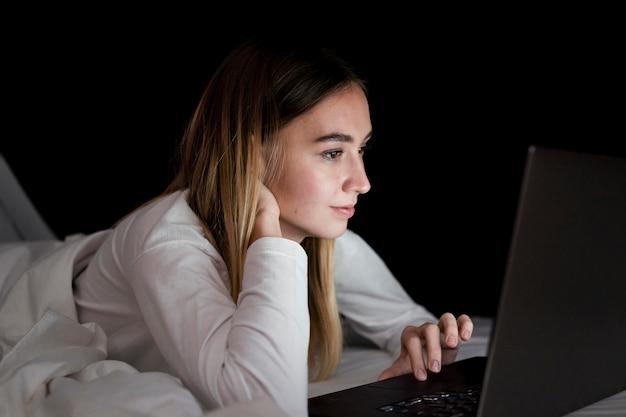 Girl at night in bed with laptop