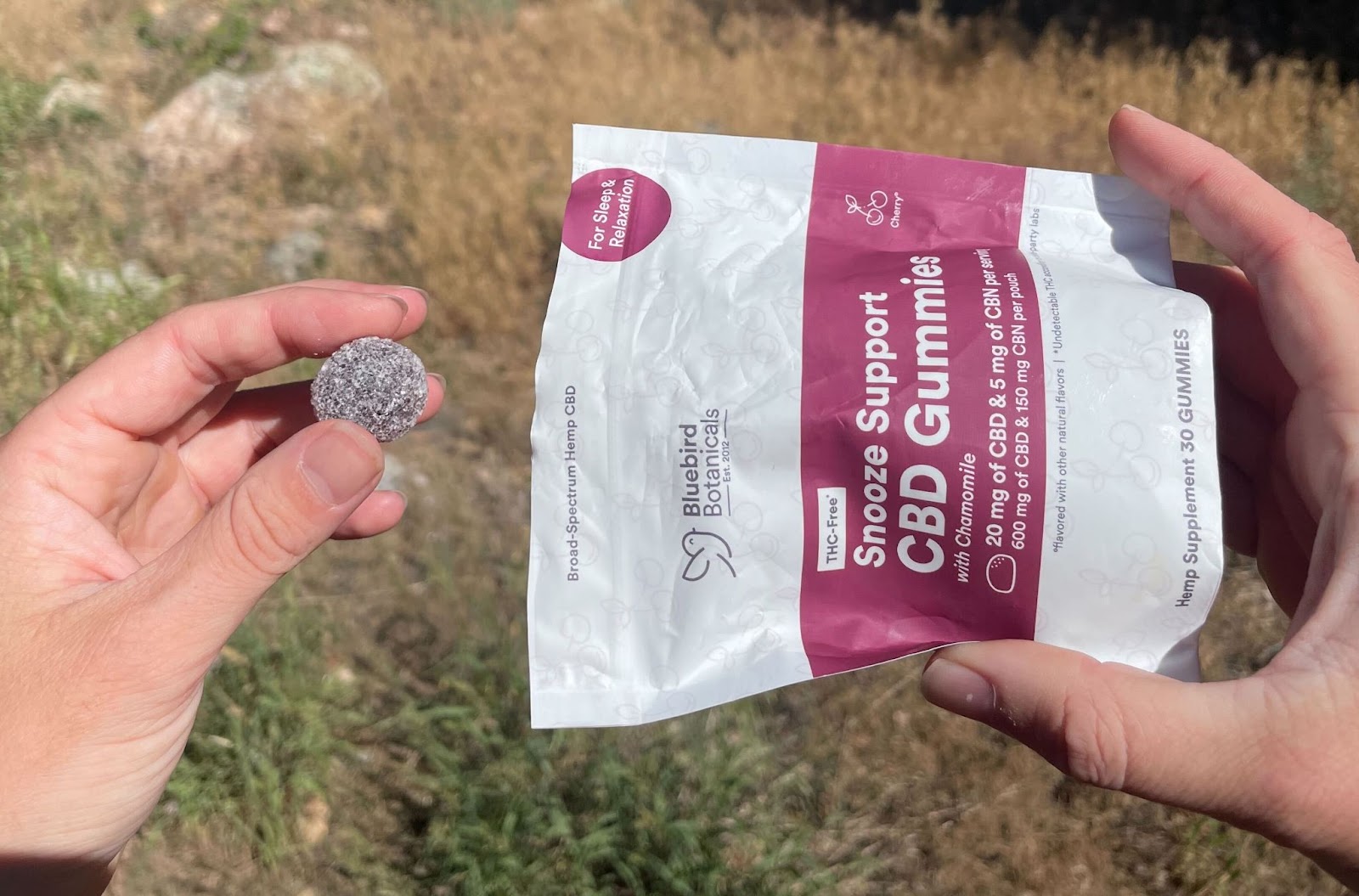 Person taking a Snooze Support gummy from the packet—CBD gummies designed for natural, melatonin-free nighttime relaxation.